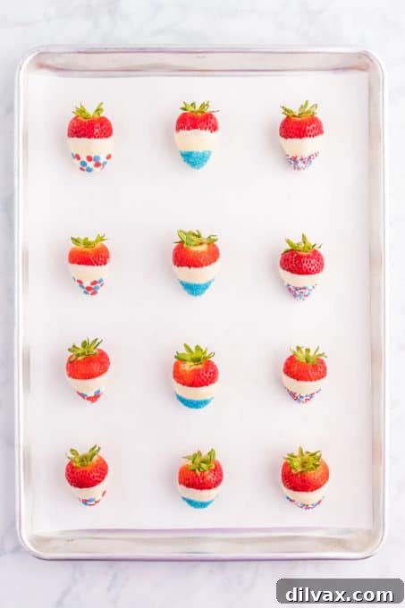 Strawberries dipped in white chocolate and red, white, and blue sprinkles on a tray