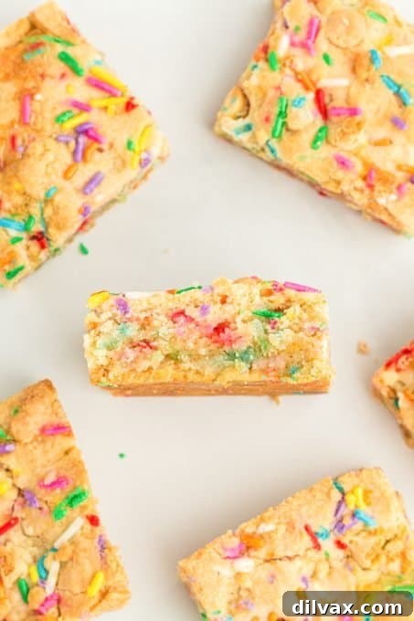 A cutting board filled with freshly sliced Funfetti Gooey Butter Bars, highlighting their soft texture and vibrant sprinkles.