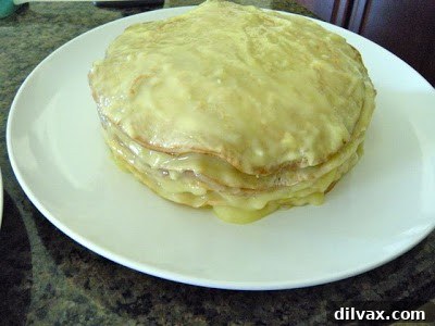 Another attempt at assembling the layered crepe cake, still appearing unstable and leaning.