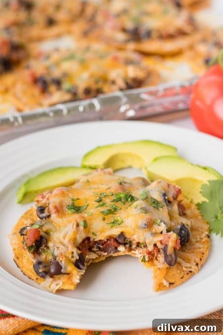 Crispy Chicken Tostadas 9 A bite taken out of a tostada topped with chicken, beans, and cheese.