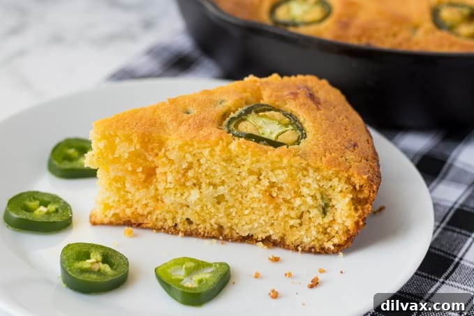 A slice of jalapeño cornbread, showcasing its cheesy interior and golden crust.
