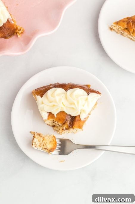 A slice of cake made of cinnamon rolls with a bite taken out.