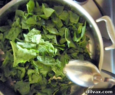 Spinach wilting in the skillet with garlic and olive oil.