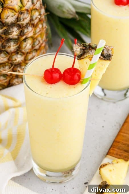 Close-up of a frosty glass of Pineapple Coconut Rum Slush, showcasing its smooth, icy texture.