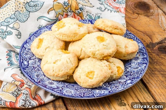 Freshly baked Peach Scones on a cooling rack, showcasing their golden-brown exterior and juicy peach chunks.