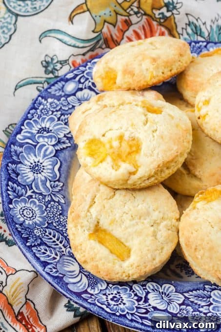 A close-up of a freshly baked peach scone, showing the texture and visible peach pieces baked within.