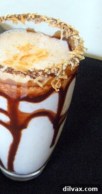 A glass of Toasted Coconut Almond Shake with a chocolate and coconut rim