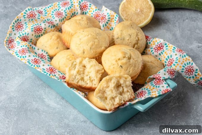 Freshly baked Lemon Zucchini Muffins cooling on a wire rack, showcasing their golden-brown tops and moist texture.