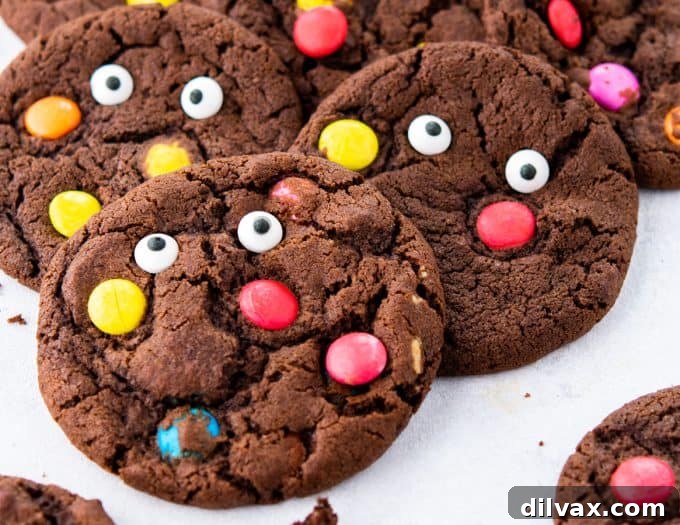 Monster Mash Cookies 2 Delicious chocolate Halloween Monster Cookies with colorful M&M candies and candy eyes, perfect for a spooky celebration.