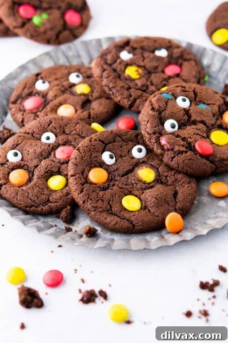 Stacked chocolate monster cookies with M&M's and candy eyes.