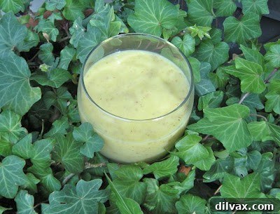 A beautiful flat lay image of a pineapple mango smoothie in a glass, surrounded by fresh slices of mango and pineapple, perfect for Pinterest sharing.