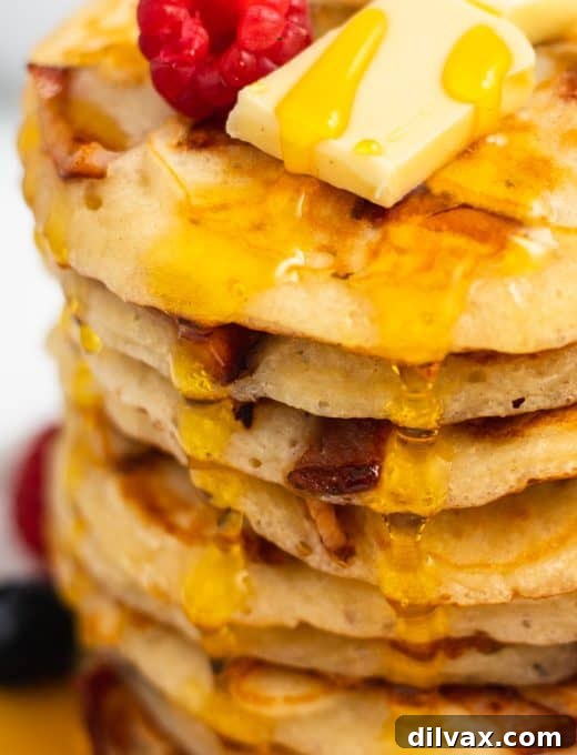 Close-up showing delightful bits of crispy bacon nestled within fluffy buttermilk pancakes, ready for breakfast.
