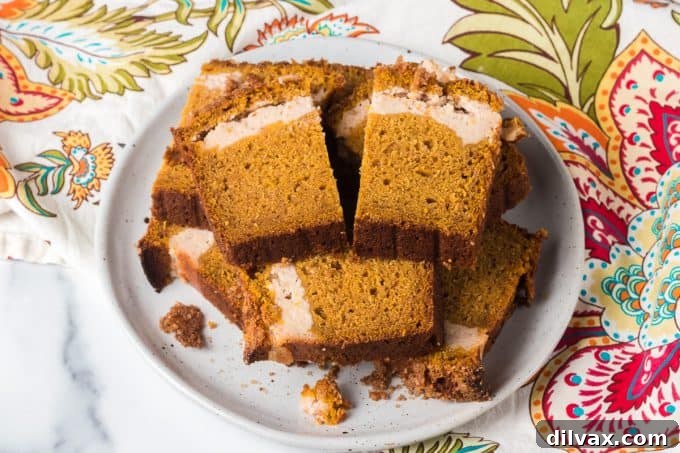 Pumpkin Cheesecake Bread 2 A delicious slice of Pumpkin Bread with a visible cream cheese filling swirl.