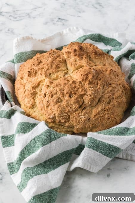 Emerald Isle's Easiest Soda Bread 9 A perfectly baked, golden-brown loaf of Irish Soda Bread sitting on a wooden surface