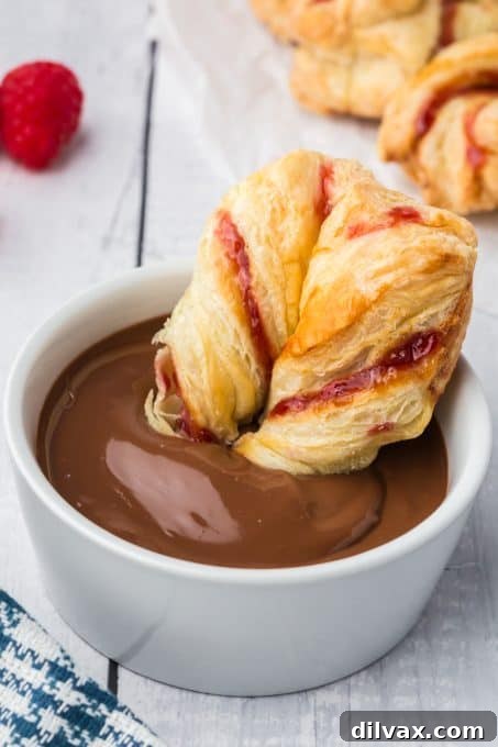 Swirling Raspberry Star Bread 11 Individual twists of Raspberry Star Bread dipped into a smooth Nutella sauce, showcasing the delicious pairing.