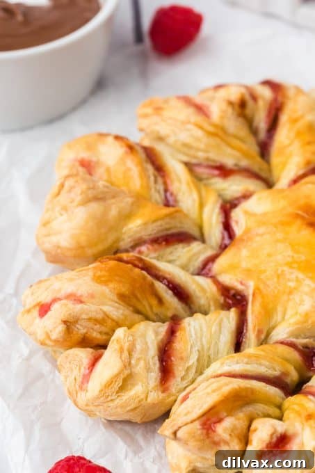 Swirling Raspberry Star Bread 9 Puff pastry star bread filled with raspberries and jam, showing a golden crust and delicate layers.