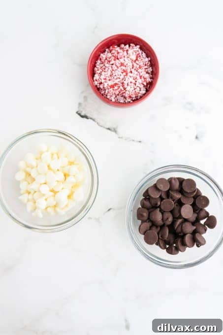 Three key ingredients for peppermint bark: dark chocolate chips, white chocolate chips, and crushed candy canes.