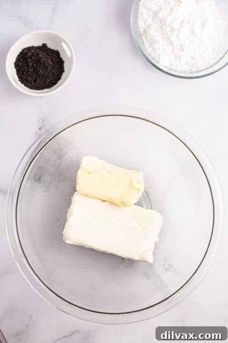 Ingredients for Oreo Cream Cheese Frosting, including butter, cream cheese, vanilla, Oreos, and powdered sugar.