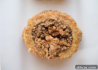 A detailed cross-section view of a Rugelach cookie, showcasing the beautiful layers of tender dough and rich fruit-nut filling.