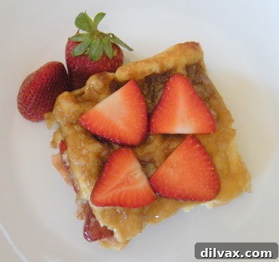 Delicious baked strawberry waffles stacked high with fresh strawberries.