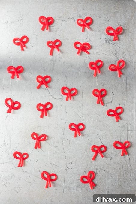 A pile of perfectly formed red licorice bows, ready to adorn the green cornflake wreaths.