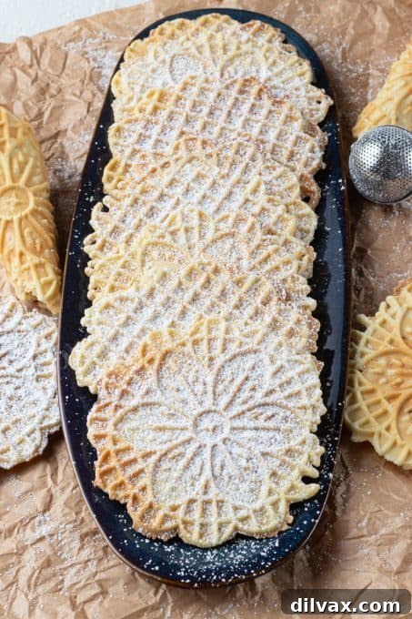 A selection of beautiful Italian cookies dusted with powdered sugar on a decorative serving platter