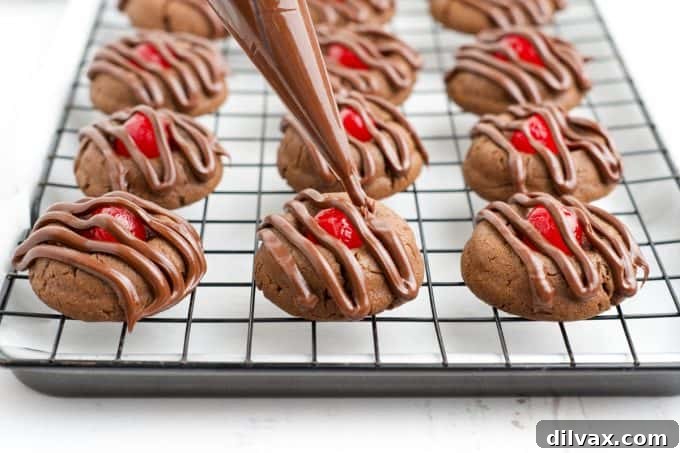 Cherry Kissed Chocolate Cookies 2 Piping rich chocolate frosting onto freshly baked cherry thumbprint cookies, ready for serving.