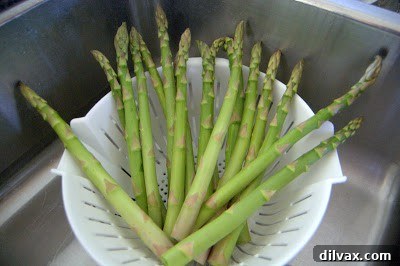 Perfectly baked asparagus spears, lightly browned and seasoned, presented on a baking sheet.