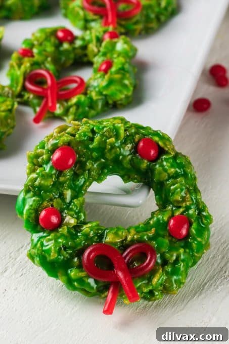 Holiday Cookie Countdown 2022 10 Festive green Cornflake Wreaths adorned with red cinnamon candies and licorice bows, perfect for Christmas.