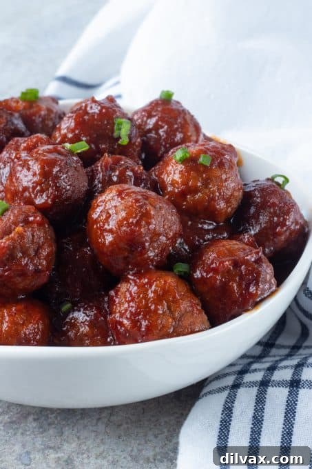 Sweet and Savory Cranberry Meatballs 10 A vibrant close-up of Cranberry Meatballs, highlighting the rich sauce and garnished with fresh green onions.