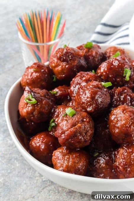 Sweet and Savory Cranberry Meatballs 7 Cranberry Meatballs in a slow cooker, garnished with fresh green onions, ready to be served at a party.