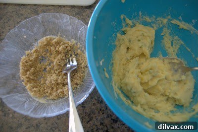 Mashed acorn squash filling in a bowl, with sour cream and green onions, ready to be mixed.
