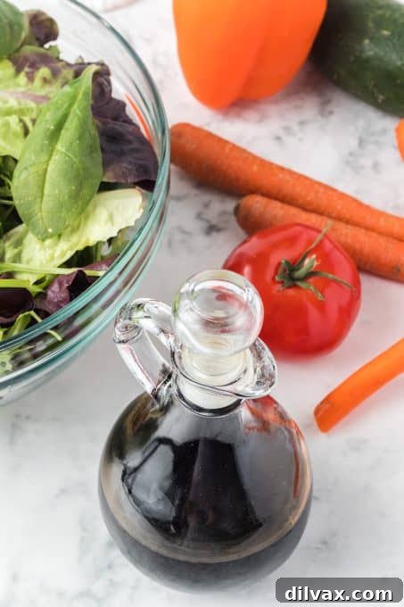 A simple still life shot featuring a bottle of balsamic vinegar and a jar of honey, the core ingredients for this easy glaze recipe, on a wooden surface.