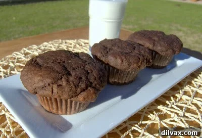 A perfectly stacked trio of double chocolate chip muffins, showcasing their fluffy texture and abundant chocolate chips.