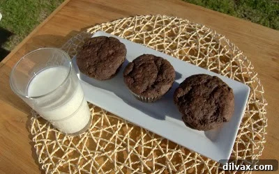 Close-up of a warm, fresh double chocolate chip muffin, highlighting the melted chocolate pieces.