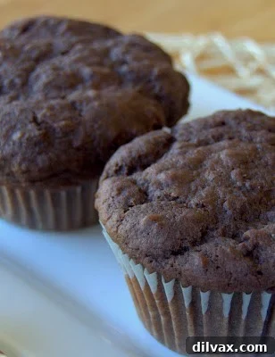 A perfectly baked double chocolate chip muffin revealing its rich interior and melty chocolate chunks, ready to be enjoyed.