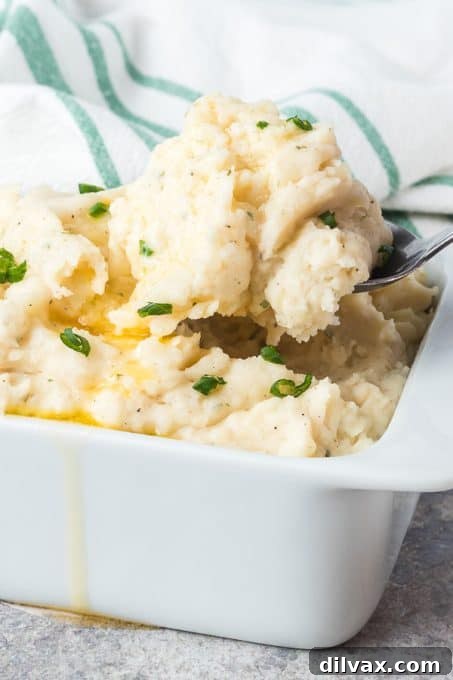 A spoonful of fluffy Ranch Mashed Potatoes being lifted from a bowl