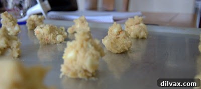 White Chocolate Cake Batter Bliss Bites 6 Cookie dough portions arranged on a baking sheet, spaced for baking.