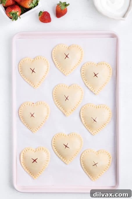 Heart-shaped hand pies filled with strawberry and cream cheese, ready for the oven