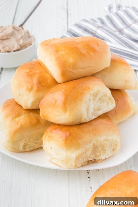 A stacked pile of golden-brown Copycat Texas Roadhouse Rolls, showcasing their soft texture.