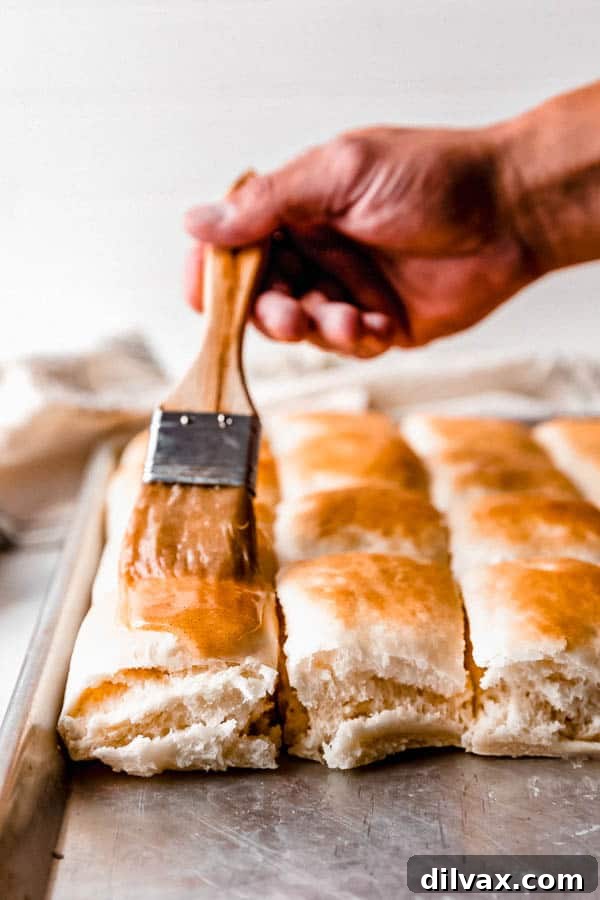 Freshly baked Copycat Texas Roadhouse Rolls, glistening with melted butter brushed on top.
