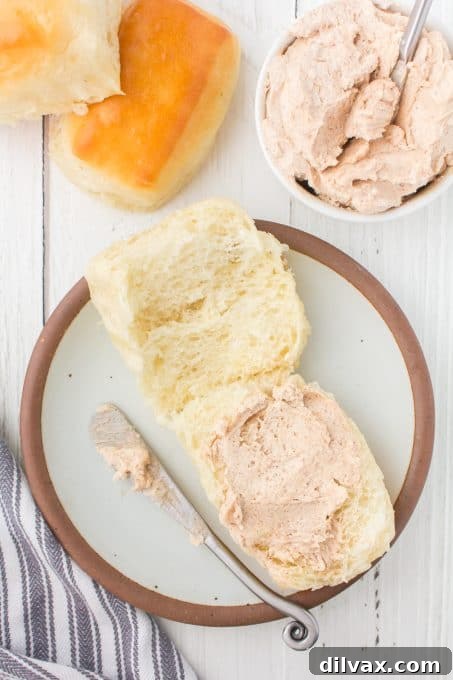 Signature Texas Roadhouse Rolls 10 Cinnamon honey butter being spread onto a soft, warm dinner roll