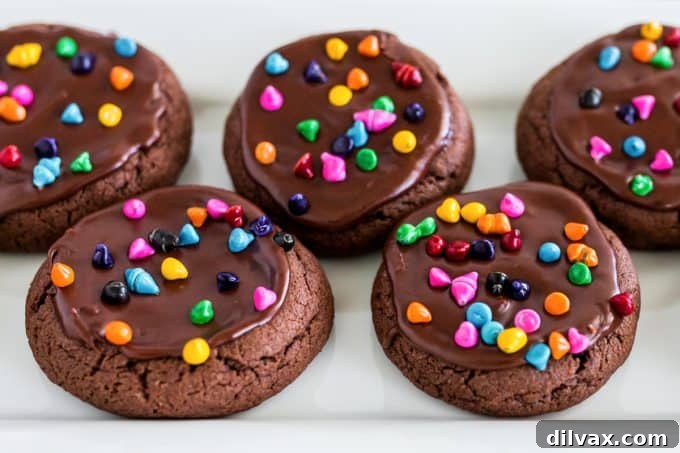 Decadent Cosmic Brownie Cookies stacked with frosting and rainbow sprinkles
