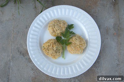 Arranging breaded potato bites on a baking sheet, ready for the oven.