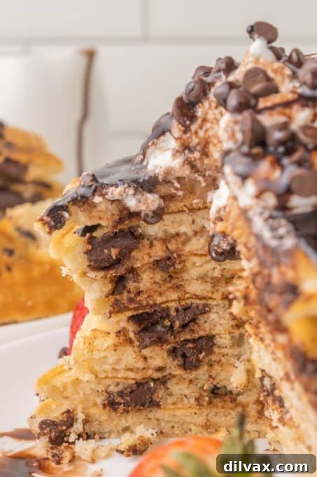 A close-up of a fluffy pancake revealing melted chocolate chips inside.