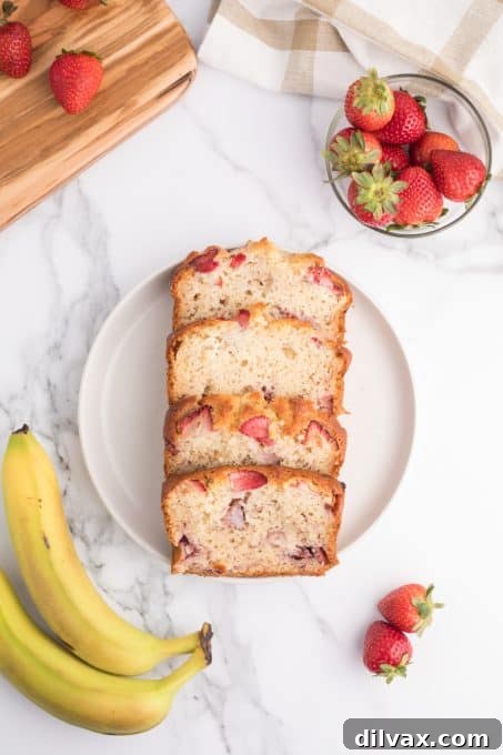 Slices of a banana quick bread with strawberries displayed
