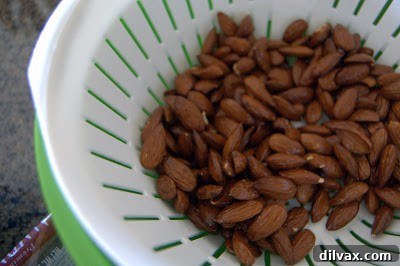 Almonds draining in a strainer after being coated