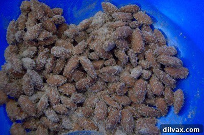 Almonds being tossed with sugar and spice mixture in a bowl