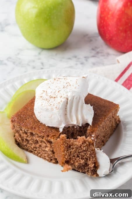 A slice of Applesauce Cake with a bite taken out, showing its fluffy texture.