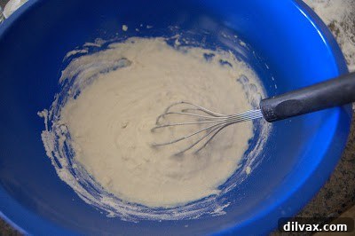 Adding more flour to the flatbread dough until it forms a ball